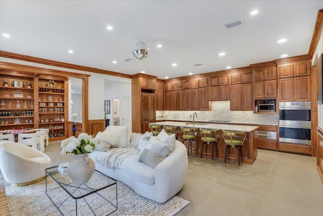 living room featuring recessed lighting, visible vents, a wainscoted wall, and crown molding