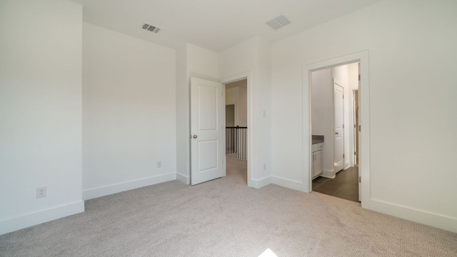 unfurnished bedroom featuring visible vents, baseboards, and carpet