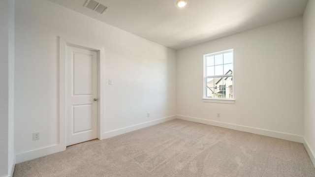 carpeted empty room with visible vents and baseboards