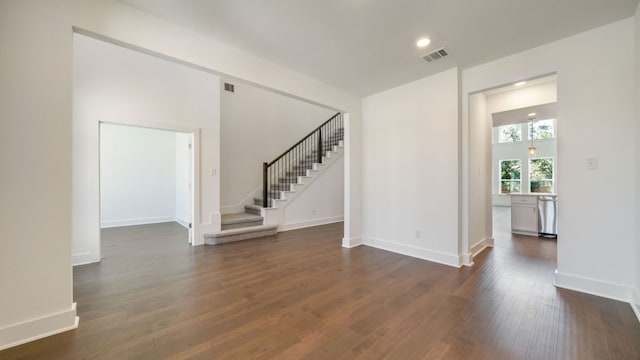 unfurnished living room with baseboards, visible vents, recessed lighting, dark wood-style flooring, and stairs