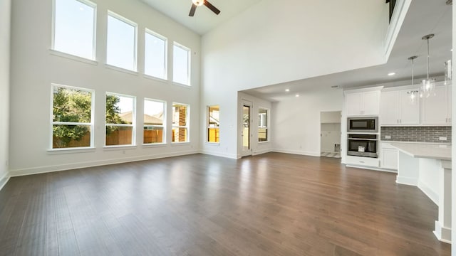 unfurnished living room featuring dark wood-style floors, recessed lighting, a fireplace, baseboards, and ceiling fan