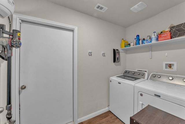 laundry room featuring visible vents, baseboards, laundry area, light wood-style floors, and washer and dryer