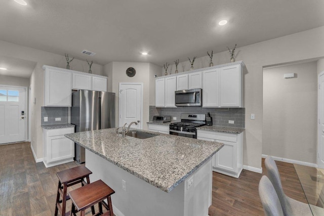 kitchen featuring visible vents, dark wood-style floors, white cabinets, stainless steel appliances, and a sink