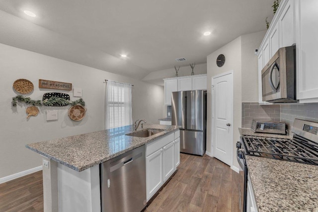 kitchen with visible vents, dark wood finished floors, stainless steel appliances, white cabinetry, and a sink