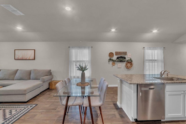 interior space featuring dishwasher, wood finished floors, visible vents, and a sink