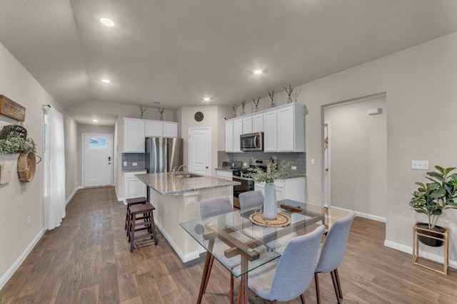 dining area featuring dark wood-type flooring, recessed lighting, baseboards, and lofted ceiling