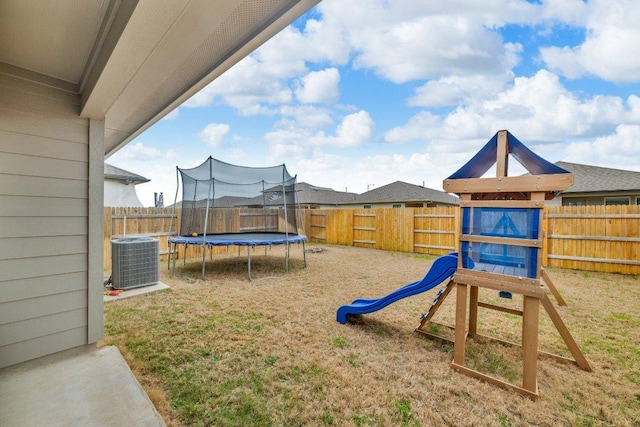 view of jungle gym with central air condition unit, a trampoline, a fenced backyard, and a yard