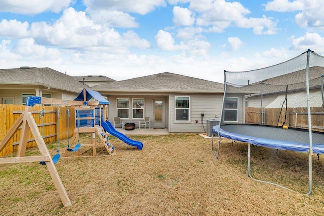 back of house featuring a patio, a fenced backyard, central AC, a playground, and a trampoline