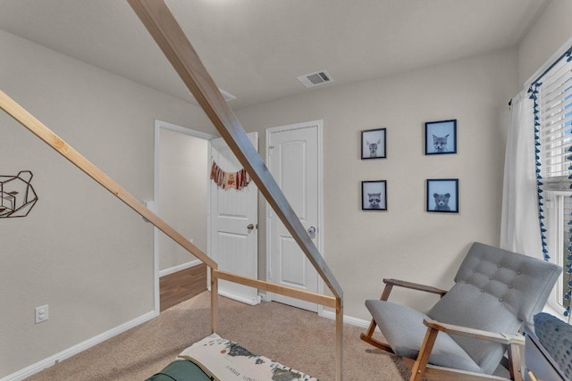 sitting room with visible vents, baseboards, carpet flooring, and stairs