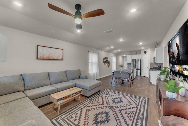 living room with vaulted ceiling, recessed lighting, dark wood-style floors, and visible vents