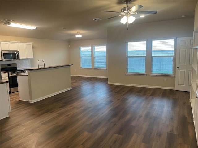 kitchen with backsplash, stainless steel appliances, visible vents, ceiling fan, and dark wood-style flooring