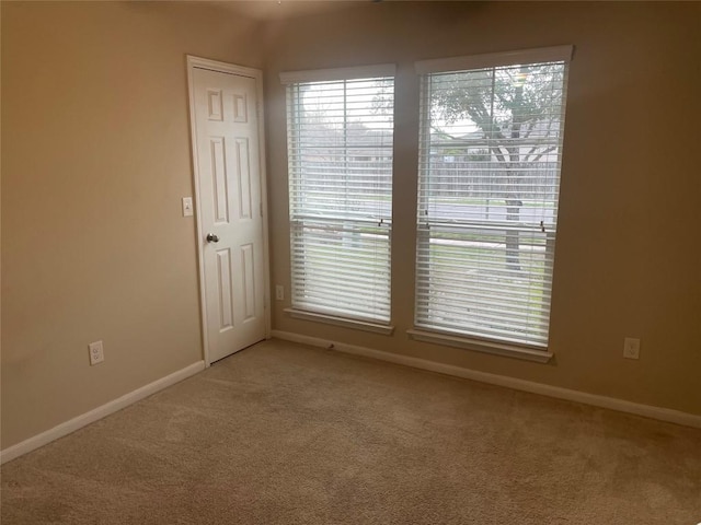 carpeted spare room featuring baseboards