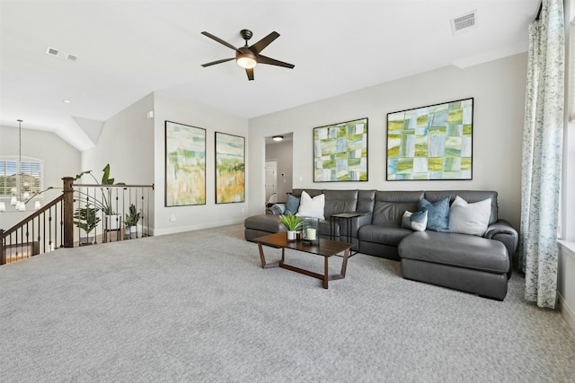 living area with visible vents, carpet floors, baseboards, and ceiling fan with notable chandelier