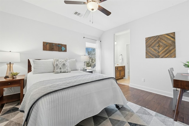 bedroom featuring visible vents, baseboards, hardwood / wood-style floors, ensuite bath, and a ceiling fan