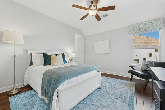 bedroom featuring visible vents, baseboards, wood finished floors, and vaulted ceiling