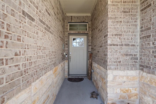 view of exterior entry with brick siding