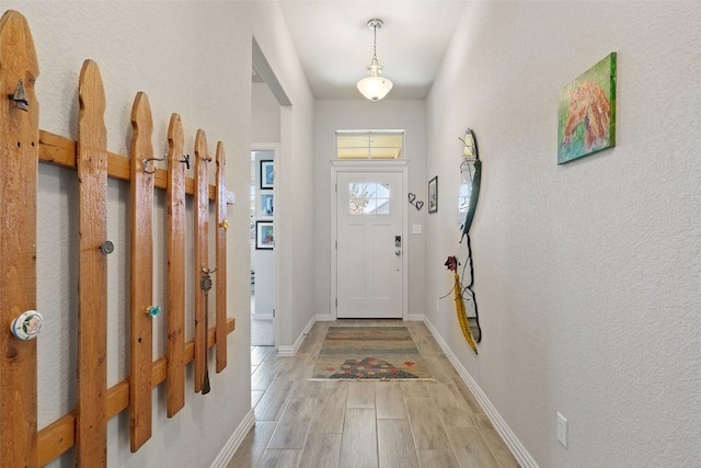 foyer with light wood-type flooring and baseboards