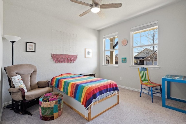 carpeted bedroom with ceiling fan and baseboards