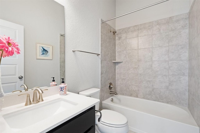 bathroom featuring toilet, vanity,  shower combination, and a textured wall