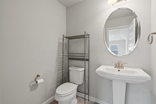 half bathroom with toilet and baseboards