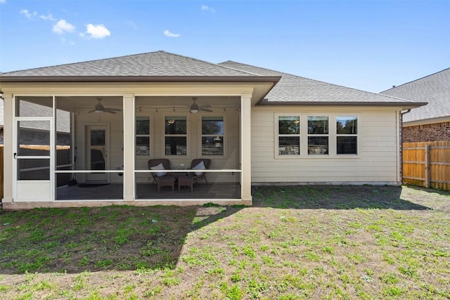 back of property featuring fence, a yard, a sunroom, ceiling fan, and a shingled roof