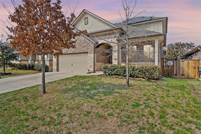 view of front of home with driveway, solar panels, a front lawn, and fence