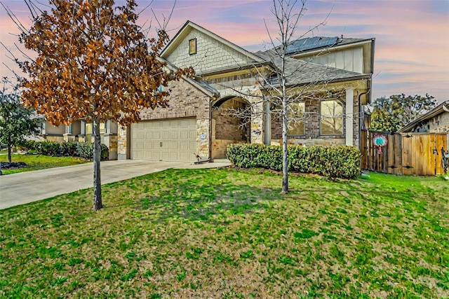 view of front of home with an attached garage, concrete driveway, a front yard, and fence