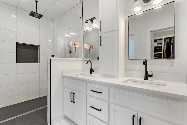 bathroom featuring double vanity, a walk in shower, and a sink