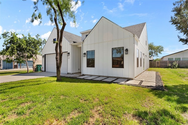 modern farmhouse featuring fence, driveway, a front lawn, a garage, and board and batten siding