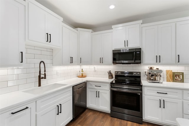 kitchen with a sink, stainless steel appliances, white cabinetry, and light countertops