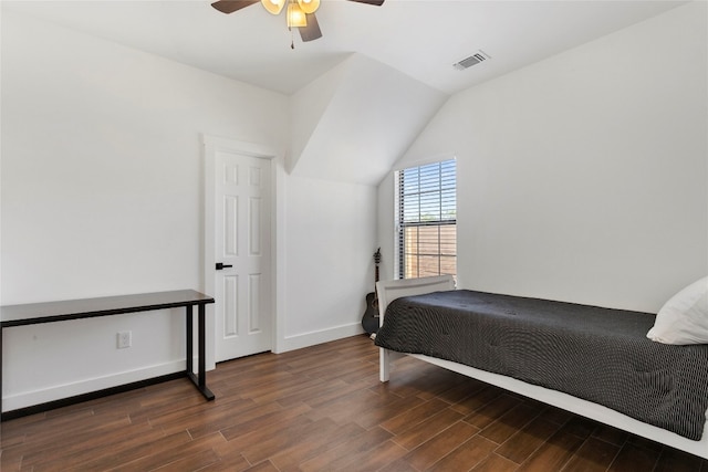 bedroom featuring a ceiling fan, wood finished floors, visible vents, baseboards, and lofted ceiling