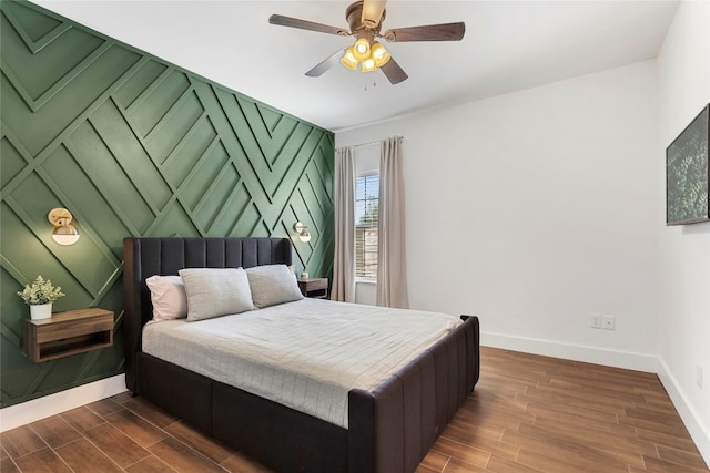 bedroom with a ceiling fan, dark wood-style floors, and baseboards