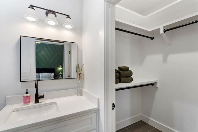 bathroom with baseboards, vanity, and tile patterned flooring