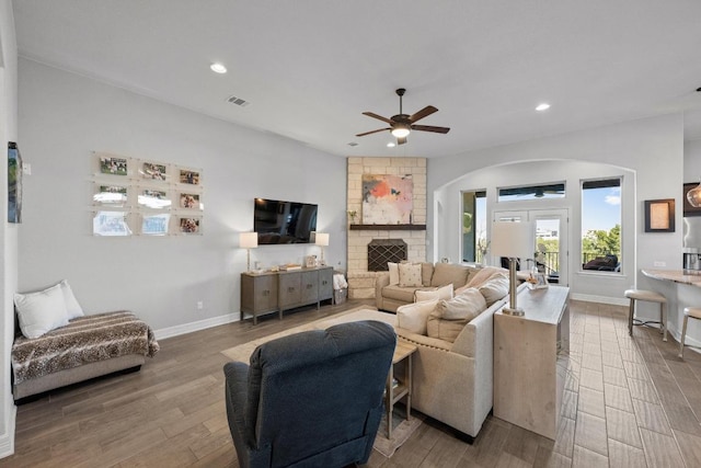 living room featuring a ceiling fan, recessed lighting, wood finished floors, and arched walkways