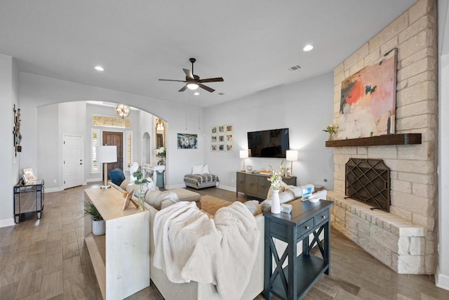 living area with wood finished floors, visible vents, recessed lighting, arched walkways, and ceiling fan