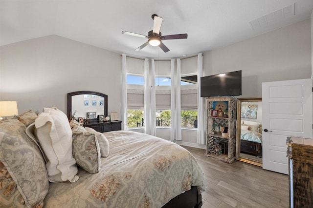 bedroom featuring visible vents, lofted ceiling, wood finished floors, and a ceiling fan