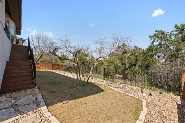 view of yard featuring stairs and a fenced backyard