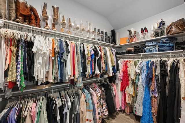 spacious closet with lofted ceiling and wood finished floors