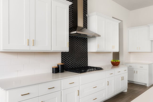 kitchen with decorative backsplash, wood finished floors, wall chimney range hood, and stainless steel gas stovetop