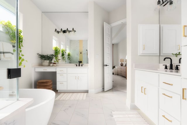 bathroom with a freestanding tub, two vanities, a sink, a shower stall, and marble finish floor