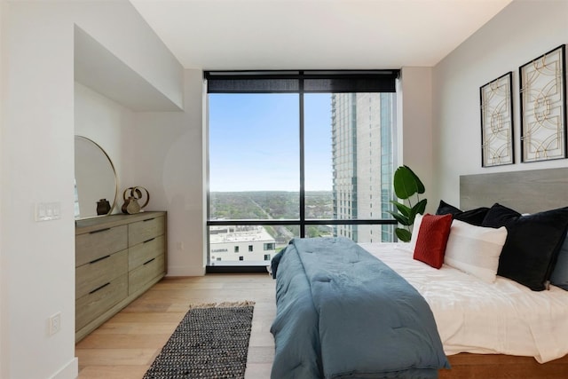 70 Rainey St Unit 1807, Austin, TX 78701 - bedroom featuring a wall of windows and light wood-style floors