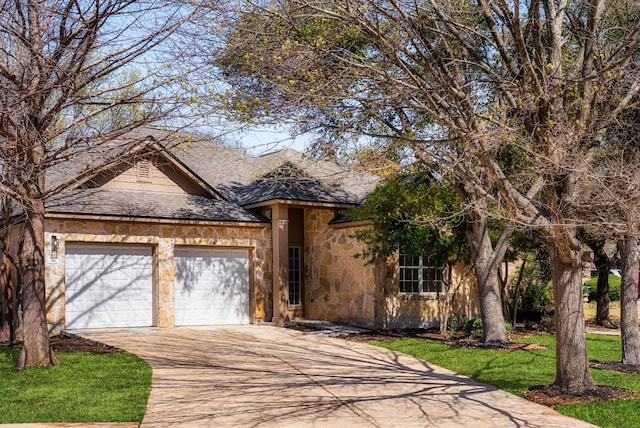 view of front of property with a shingled roof, a front lawn, concrete driveway, stone siding, and an attached garage