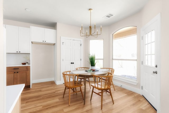 dining space with a chandelier, visible vents, a healthy amount of sunlight, and light wood-type flooring