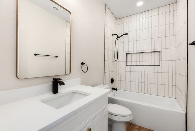 bathroom with visible vents, toilet, wood finished floors, tub / shower combination, and vanity