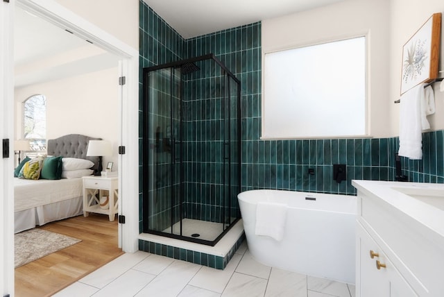 full bath with a freestanding tub, tile walls, ensuite bath, and a shower stall