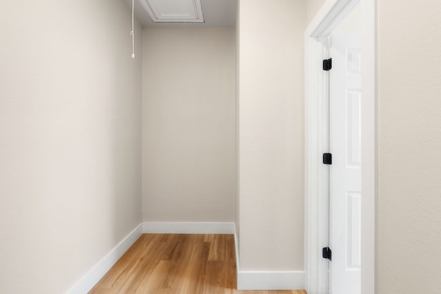 hall with baseboards and light wood finished floors