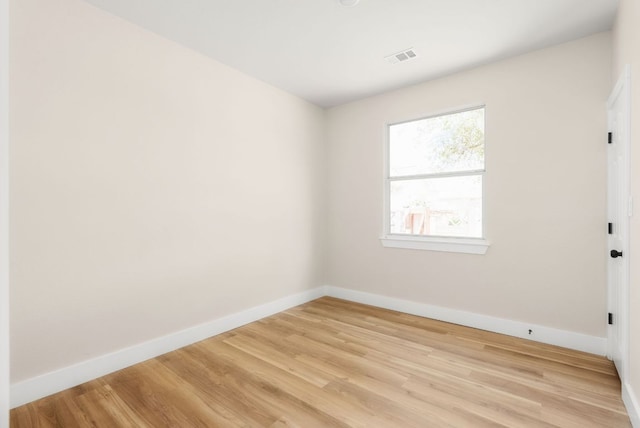 unfurnished room featuring light wood-type flooring, baseboards, and visible vents