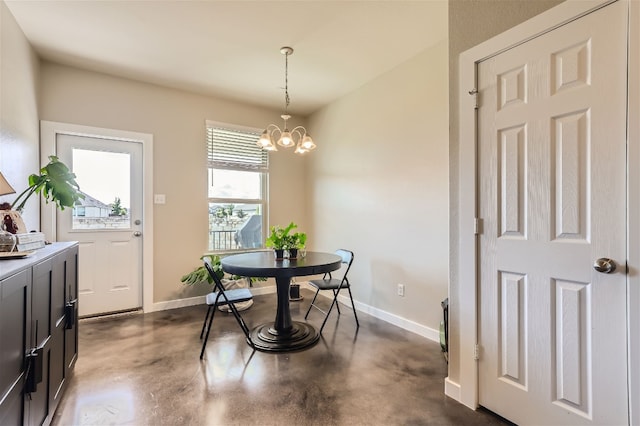 dining room with finished concrete flooring, baseboards, and a chandelier