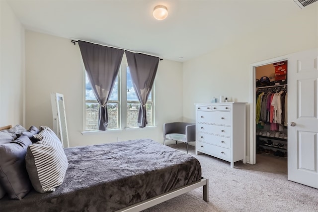 carpeted bedroom with a walk in closet, a closet, and visible vents