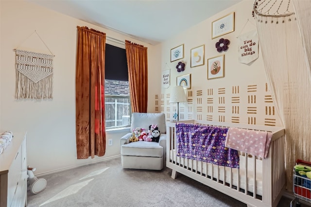 bedroom with a nursery area, baseboards, and carpet floors